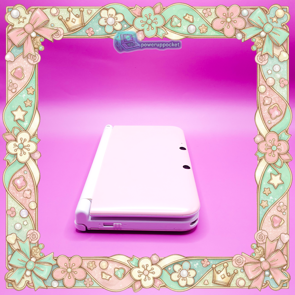 Angled left-side view of a custom Nintendo 3DS XL with pink shell and white trim, shown closed on a pink background.